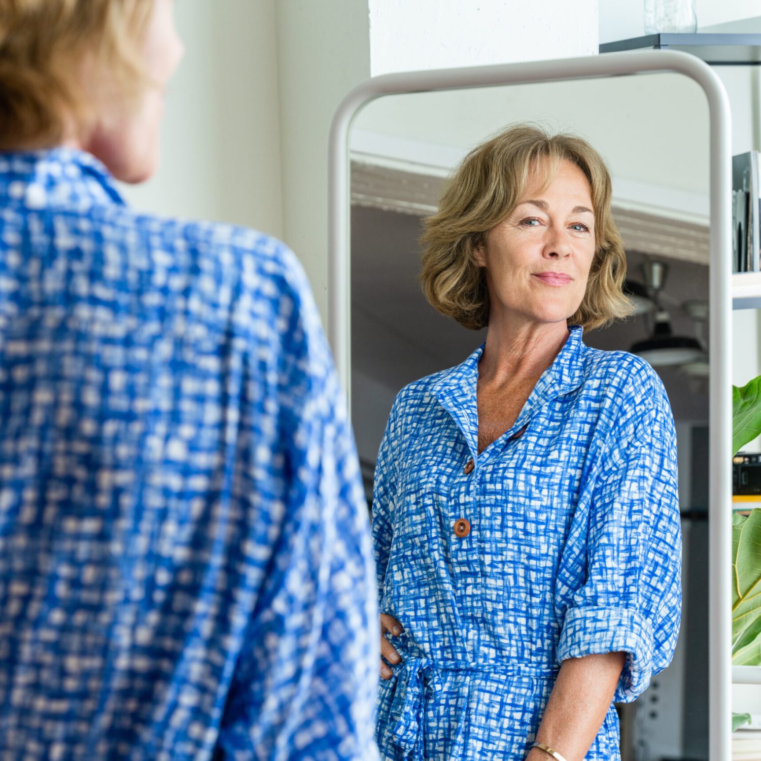 Beautiful mature senior woman at home, domestic life and leisure moments - 50-60 years old pretty female adult looking at herself in the mirror